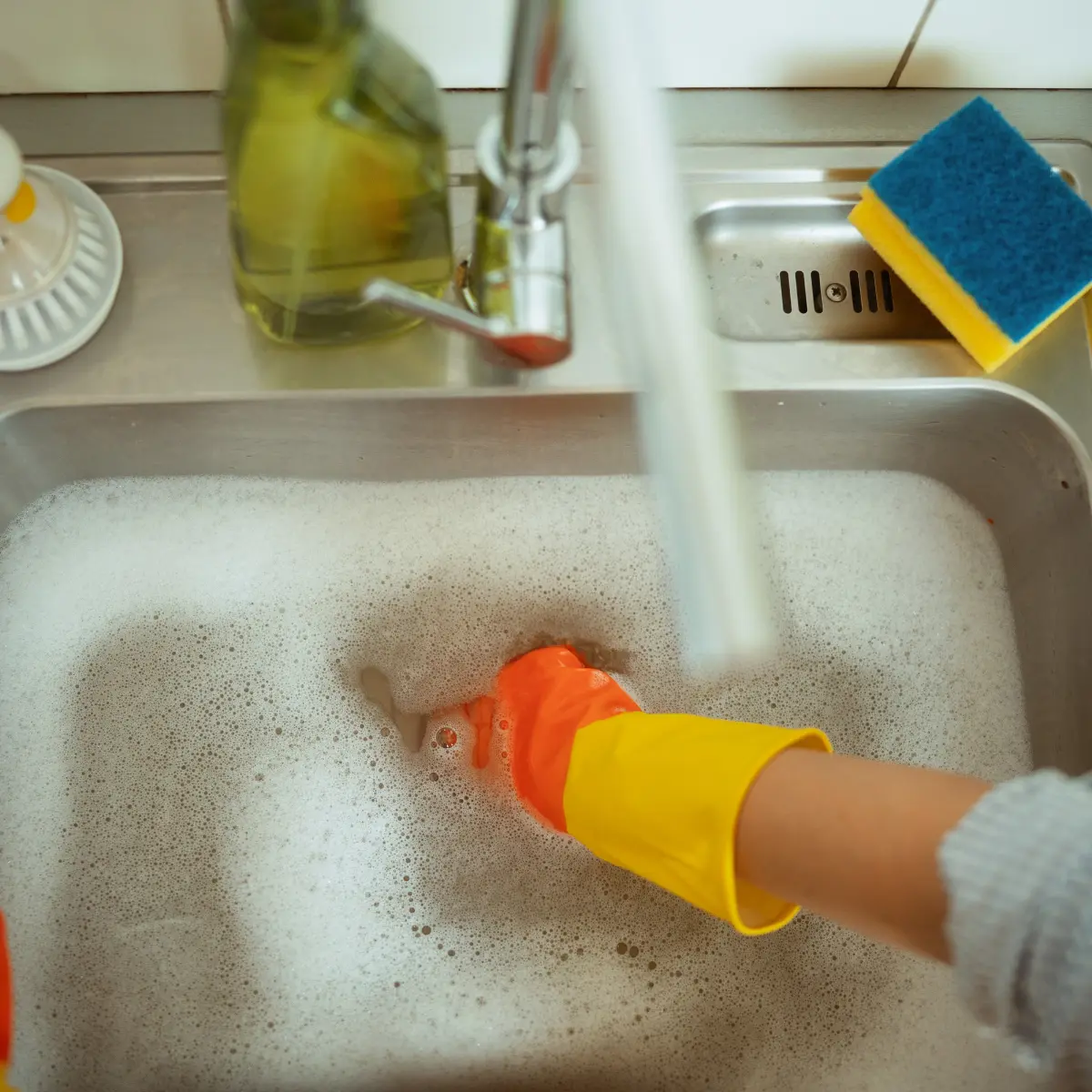 Rensar avloppet med diskhandskar vattenlås